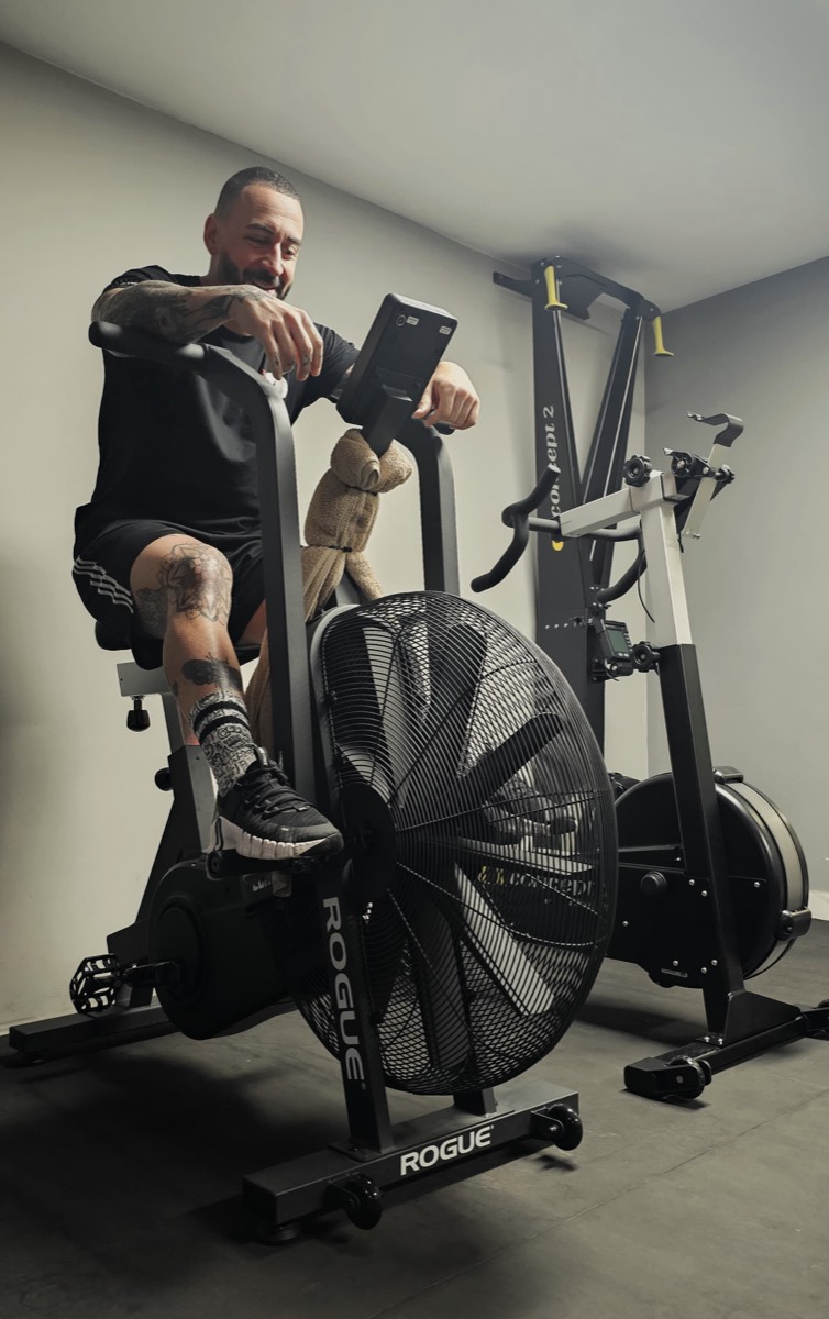 Athlete driving a Rogue air bike during a conditioning session
